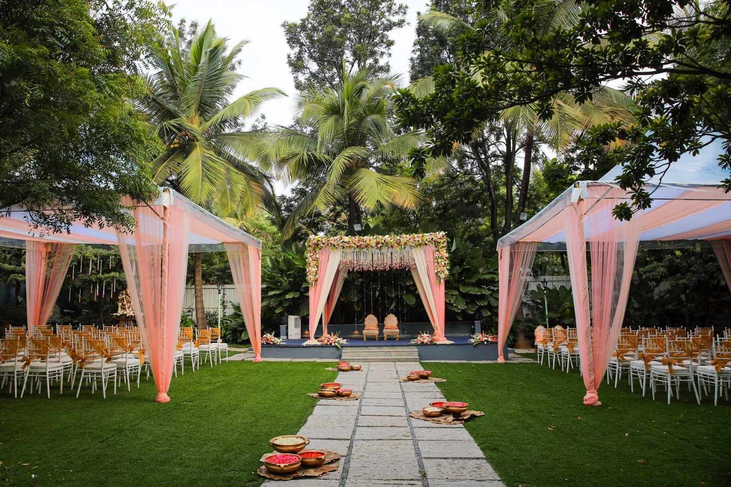 Destination wedding cost setup with outdoor mandap decor and seating arrangement at a garden venue